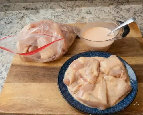 KFC Nashville Hot Chicken Combos are Back in 2026 11 Preparing the marinade for KFC Nashville Hot Tenders with a bowl of spicy buttermilk wash and chicken ready for soaking.